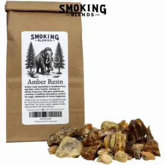 A tin-tie kraft paper bag with a white label featuring the SmokingBlends.com logo, an illustration of a mammoth walking through a pine forest, a product description, and a marked 2 oz box. A pile of amber resin incense chunks of mixed colors, including deep mahogany, golden amber, sandy tan, and pale yellow, sits in front of the bag. Pieces range from small pebbles to around an inch; some are smooth and glassy, others rough and matte.